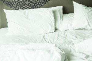 messy-bed-with-white-sheets_1203-615